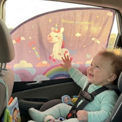 Pare soleil voiture bébé d'un bébé qui regarde et touche le motif dessiné en souriant.